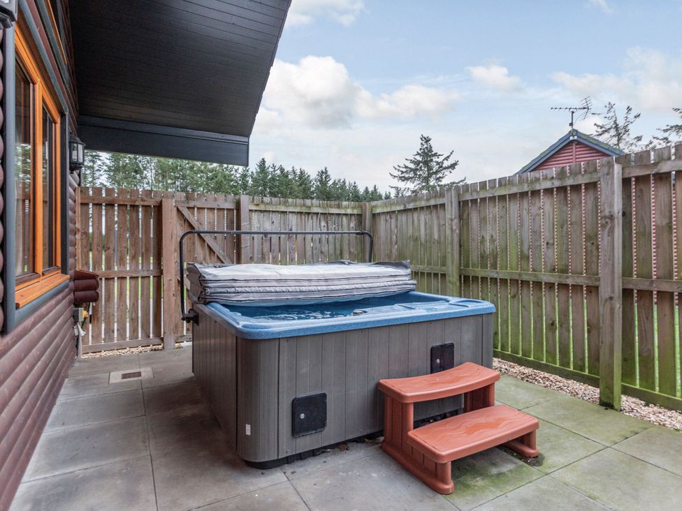 A hot tub with steps on a patio at Rainbow Spa (Pet) Dundee