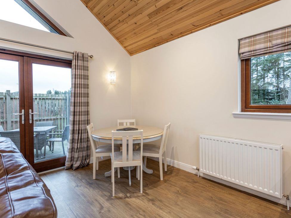 A dining room with a round table and chairs at Raeburn Premier Spa in Dundee