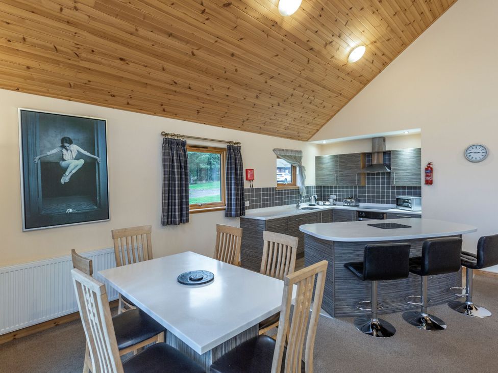 A kitchen with dining table and chairs at Rainbow Spa Plus (Pet) in Dundee