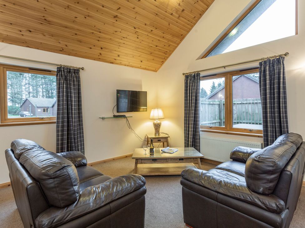 A living room with sofas and a television at Rainbow Spa Plus (Pet) in Dundee
