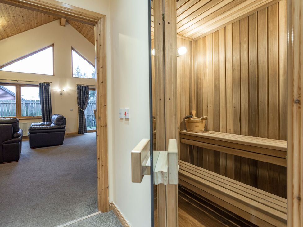 A sauna with wooden benches and bucket at Rainbow Spa Plus (Pet) in Dundee