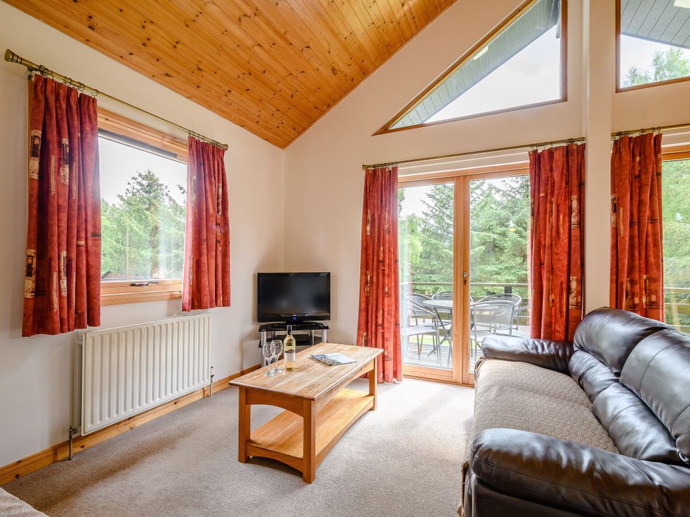 A living room with a television and sofa at Osprey Lodge in Dundee