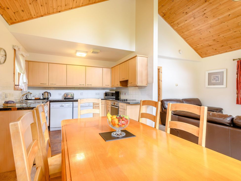A kitchen with a dining table and chairs at Osprey Lodge in Dundee