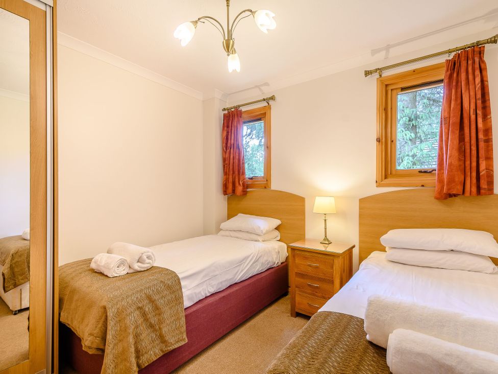 A bedroom with two beds and a bedside table at Osprey Lodge in Dundee