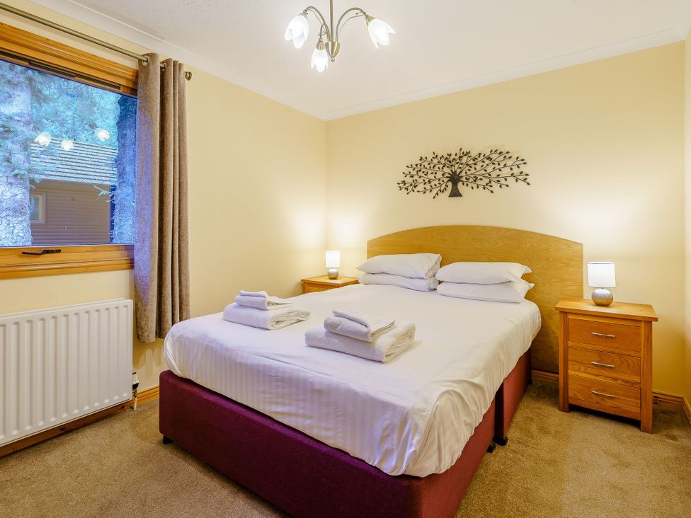 A bedroom with a bed and nightstands at Osprey Spa in Dundee