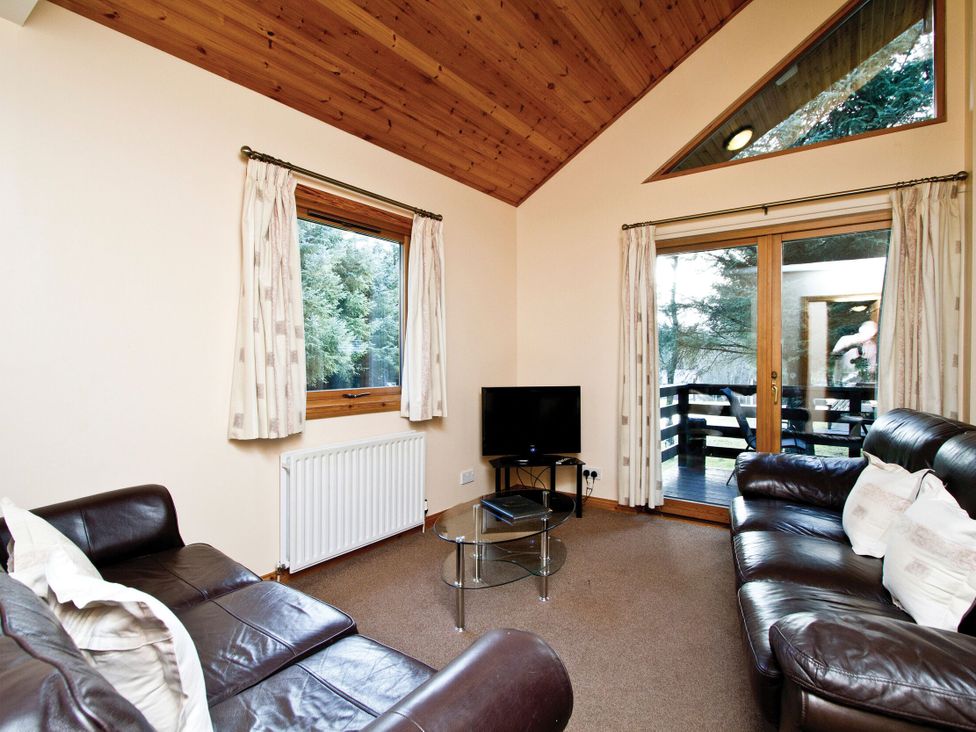 A living room with a sofa and television at Osprey Spa in Dundee