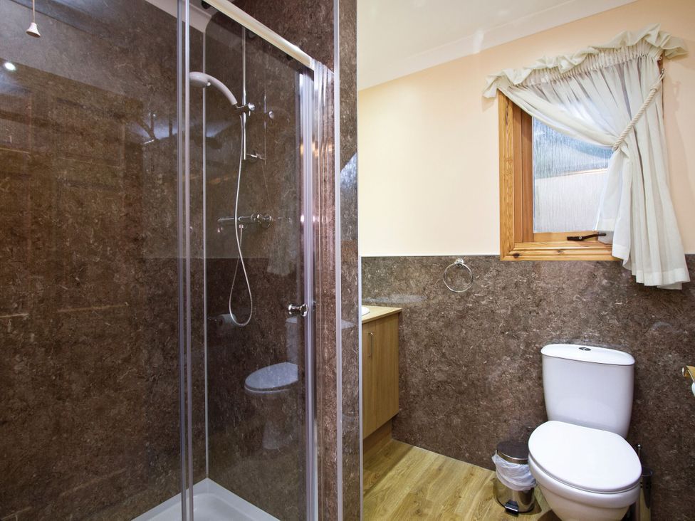 A bathroom with a shower, toilet, and sink at Osprey Spa in Dundee