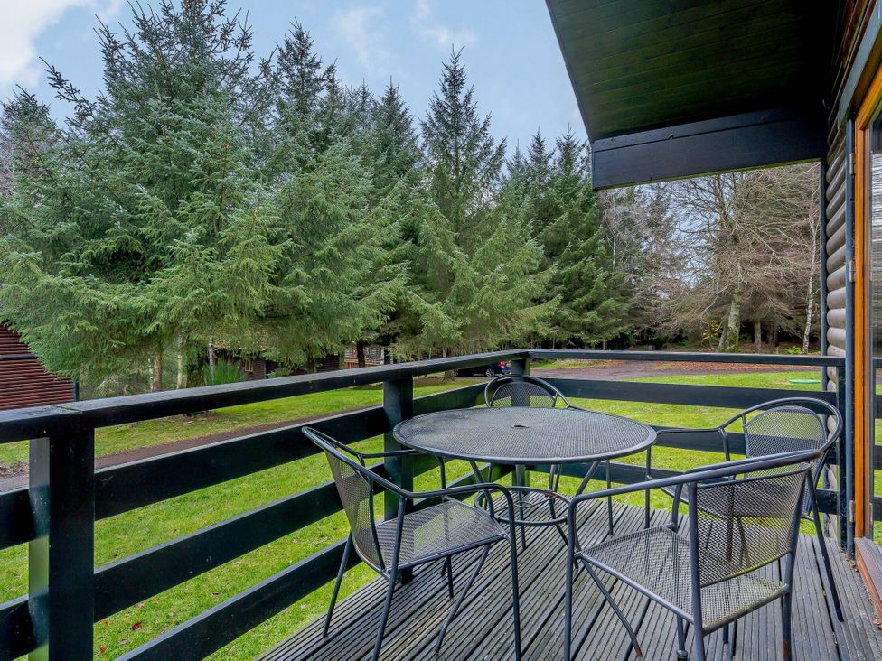 An outdoor seating area with a table and chairs at Osprey Spa (Pet) Dundee