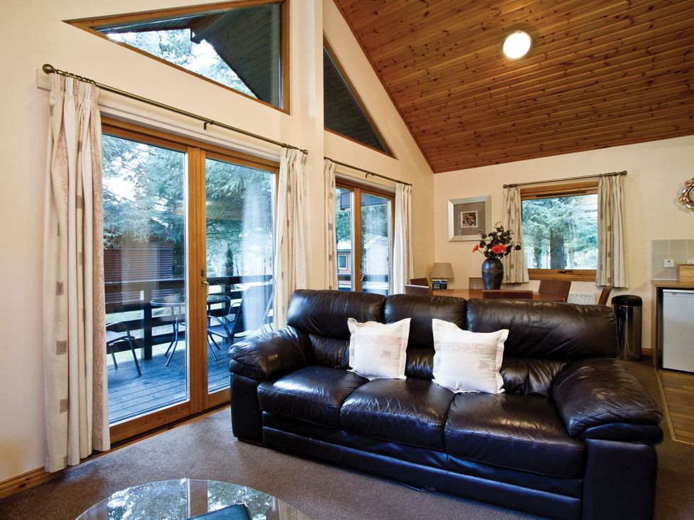 A living room with a sofa and dining table at Osprey Spa (Pet) Dundee