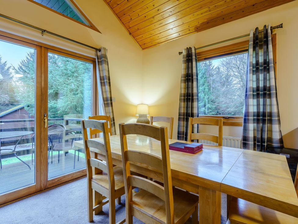 A dining room with a table and chairs at Osprey Lodge (Pet) Dundee