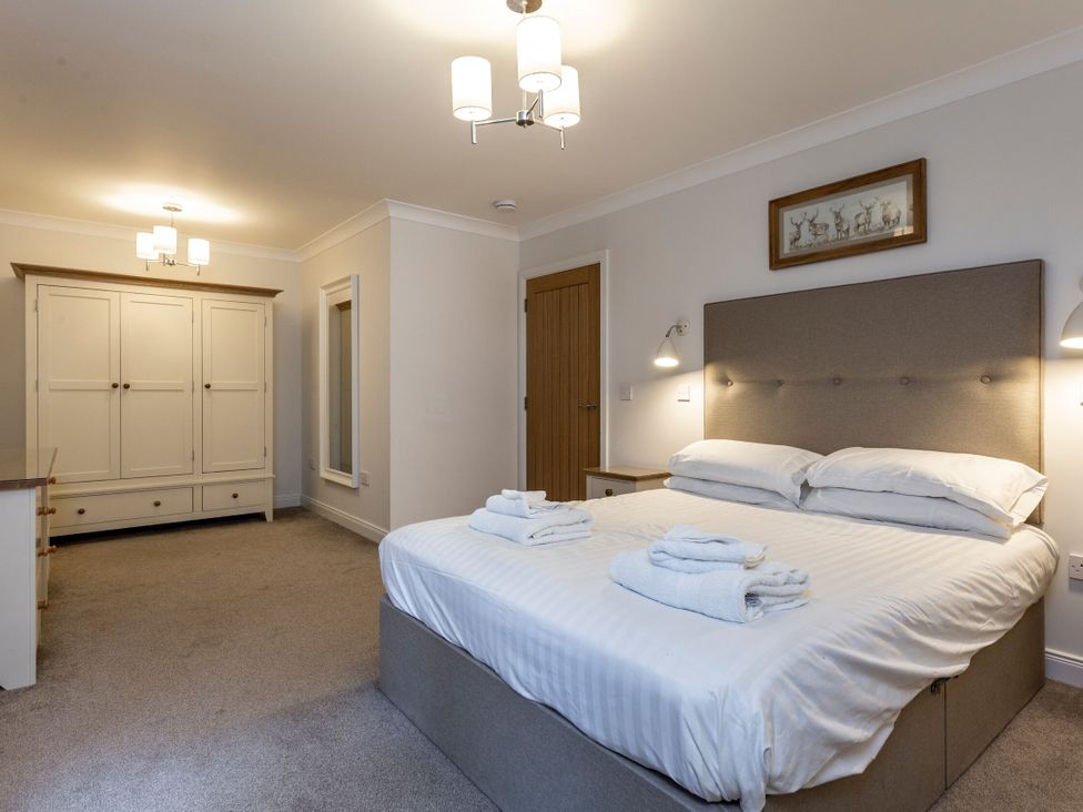 A bedroom with a bed and wardrobe at Galbraith Premier Spa (Pet) in Dundee