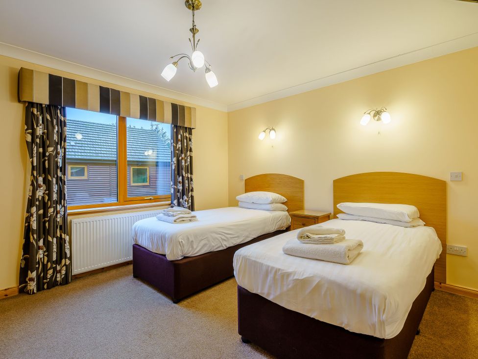 A bedroom with two beds and a window at Osprey Spa Plus in Dundee