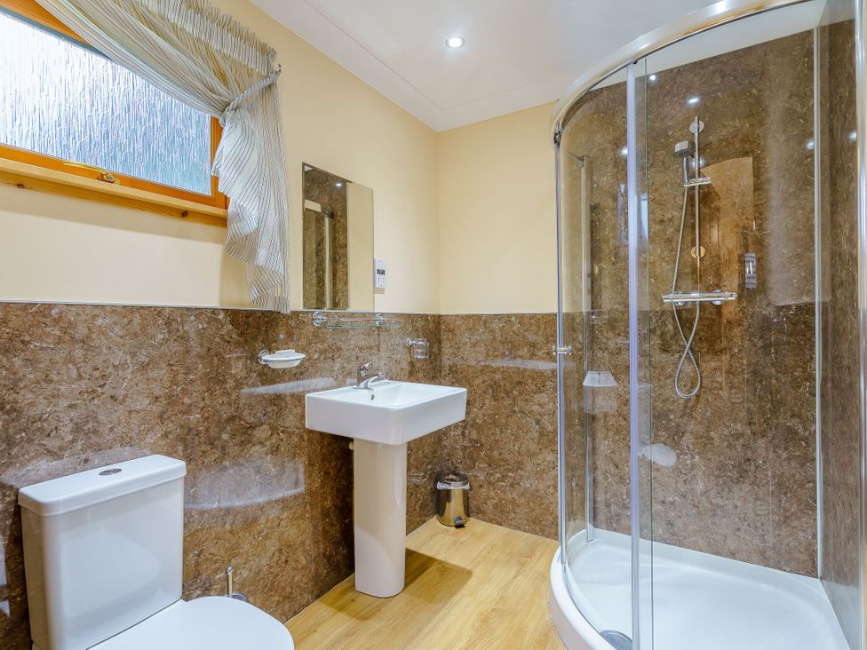 A bathroom with a shower and sink at Osprey Spa Plus (Pet) Dundee
