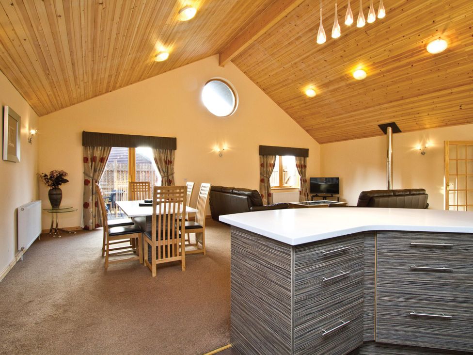 A dining room with table and chairs at Osprey Spa Plus (Pet) in Dundee