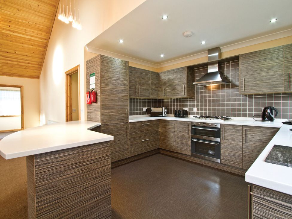 A kitchen with cabinets and appliances at Osprey Spa Plus (Pet) Dundee