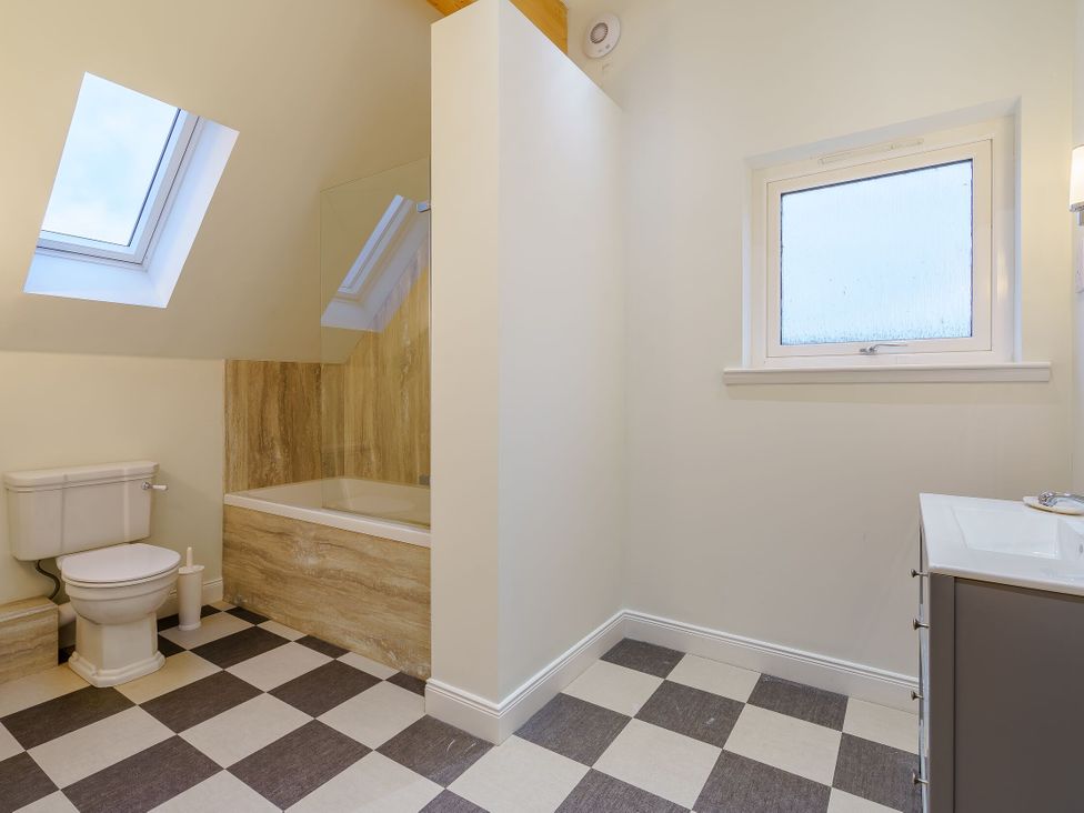 A bathroom with a bathtub, toilet, and sink at Lochside Premier Spa in Dundee