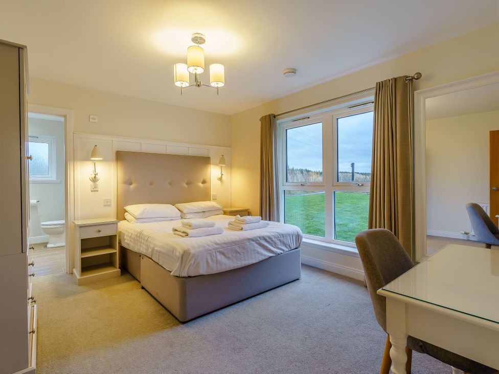 A bedroom with a bed and desk at Lochside Premier Spa (Pet) in Dundee