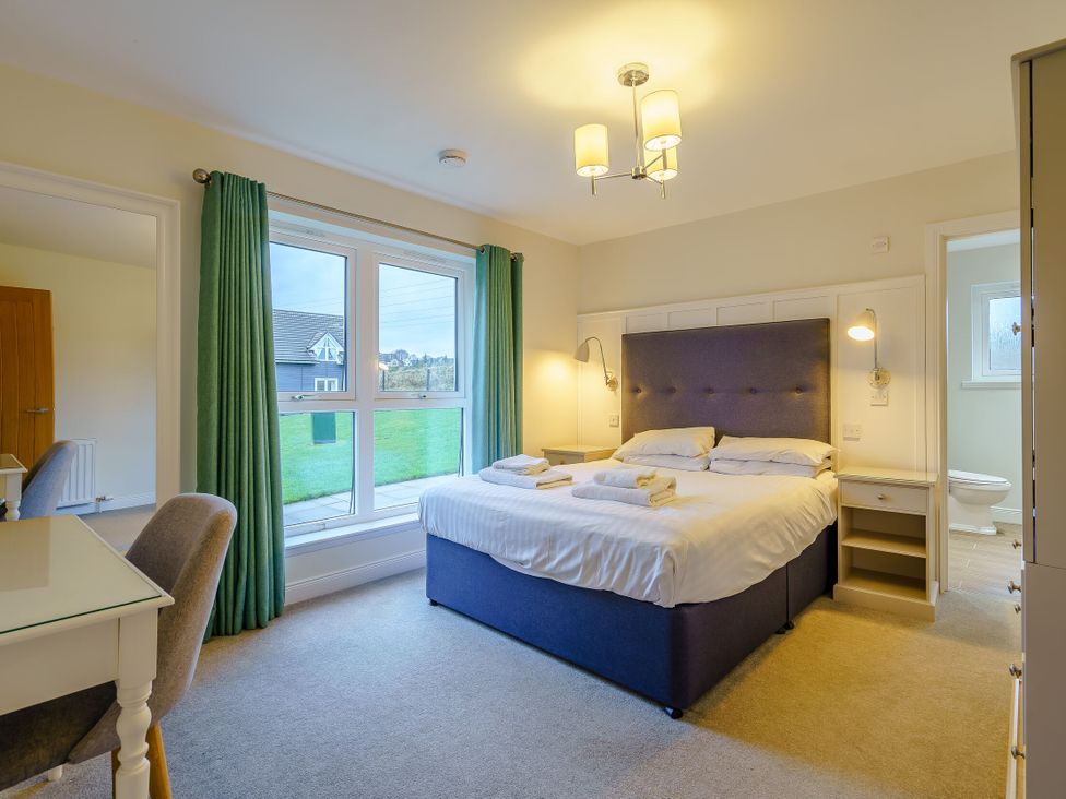 A bedroom with a bed and desk at Lochside Premier Spa (Pet) in Dundee