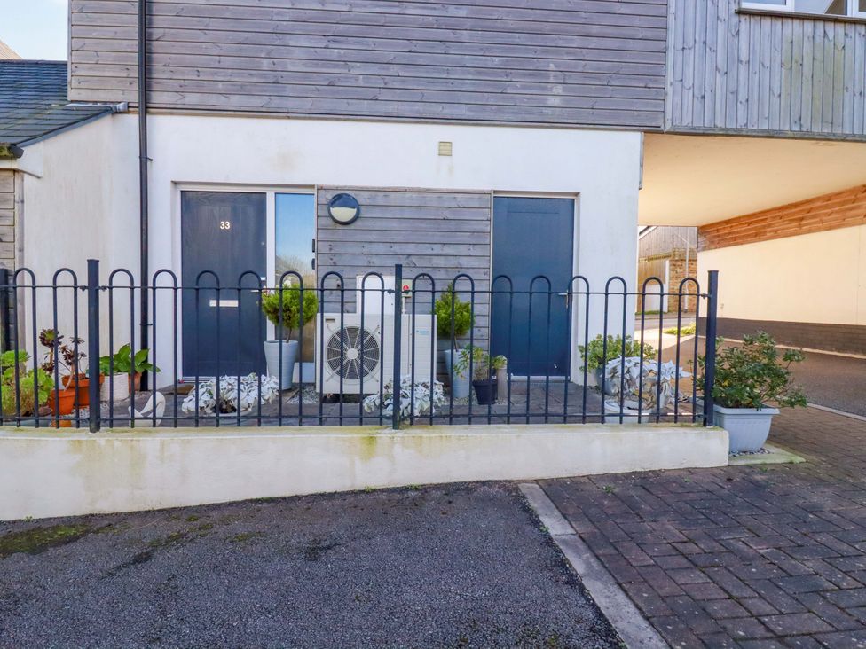 An outdoor space with a fence, door, plants, and an air conditioning unit at 33 Fordh Tobmen St. Agnes