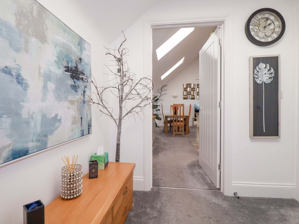 A hallway with wall art, a tree decoration, and a console table at 33 Fordh Tobmen in St. Agnes