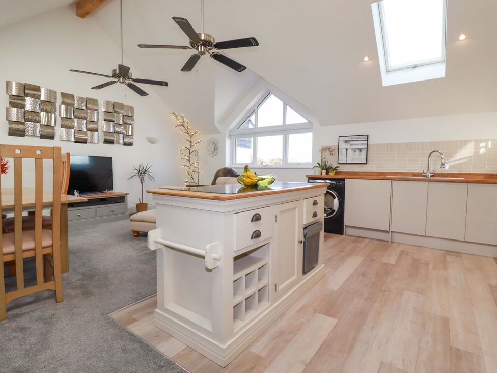 A kitchen with an island, dining table, and television at 33 Fordh Tobmen St. Agnes