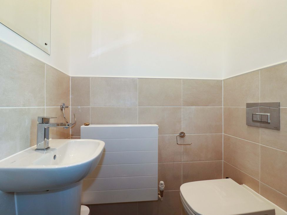 A bathroom with a sink, toilet, and radiator at 33 Fordh Tobmen in St. Agnes