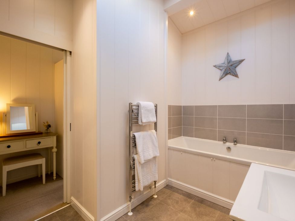 A bathroom with a bathtub and towel rack at Belfry Waltham