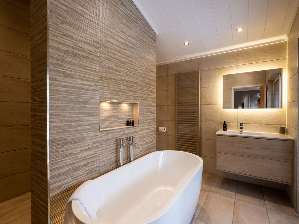 A bathroom with a bathtub and sink at Moonlight Spa Luxury in Waltham