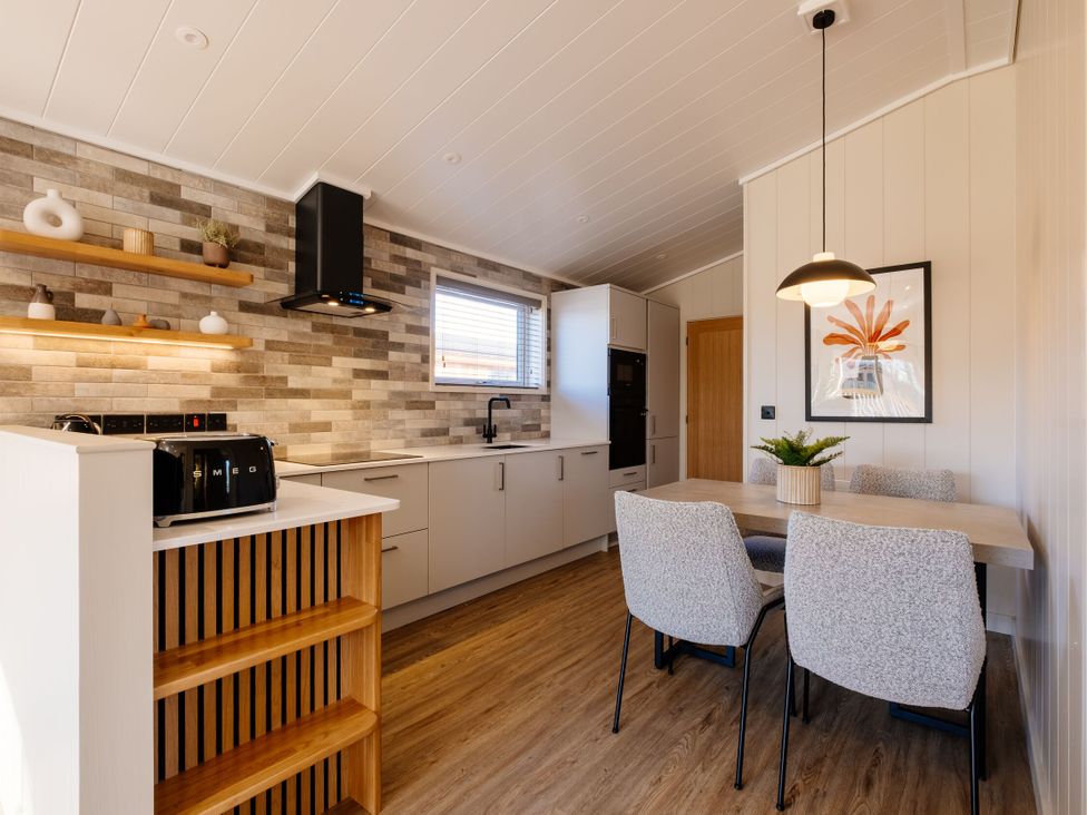A kitchen with cabinets and dining area at Luxury One Bedroom Retreat in Waltham