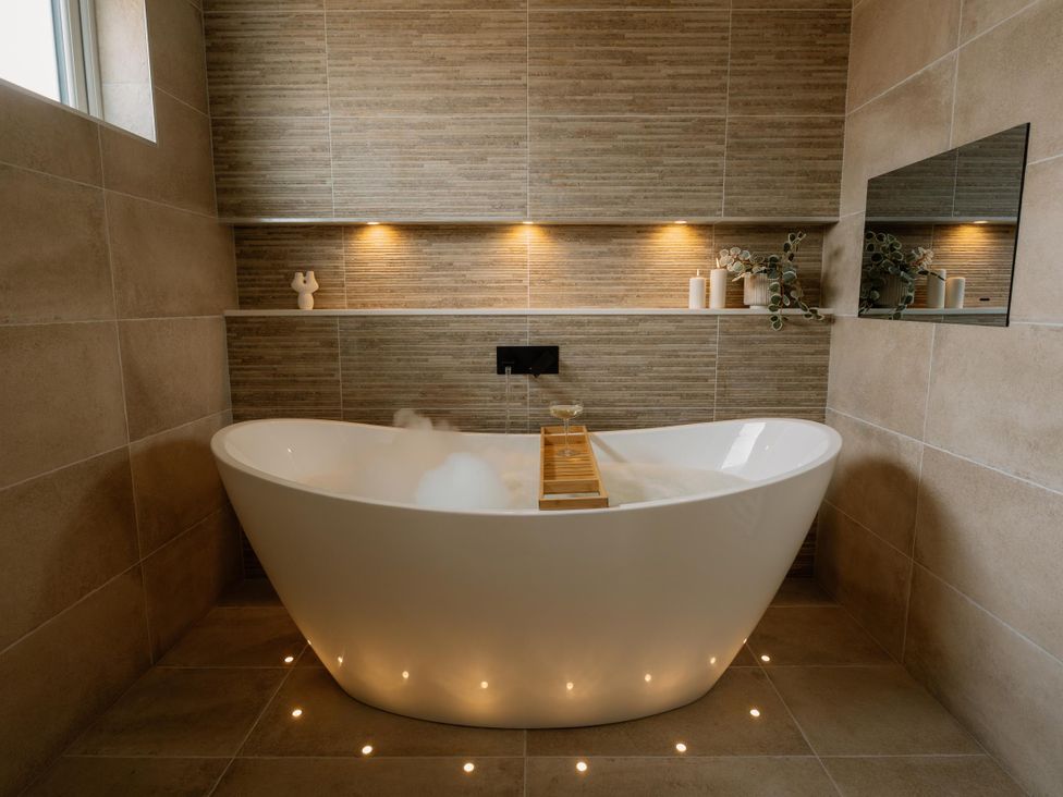 A bathroom with a bathtub and candles at Luxury One Bedroom Retreat in Waltham