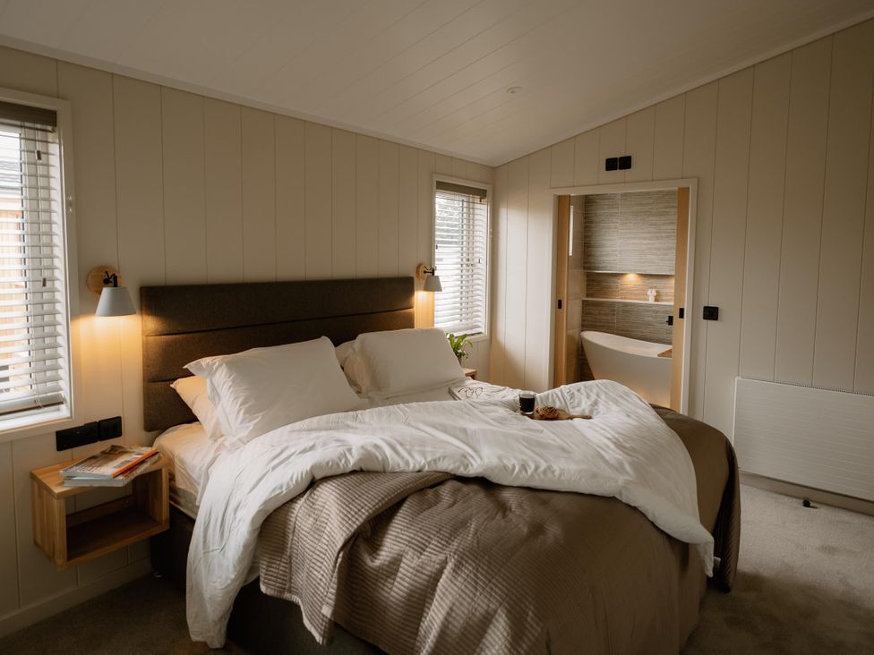 A bedroom with a bed and a bathroom door at Luxury One Bedroom Retreat in Waltham