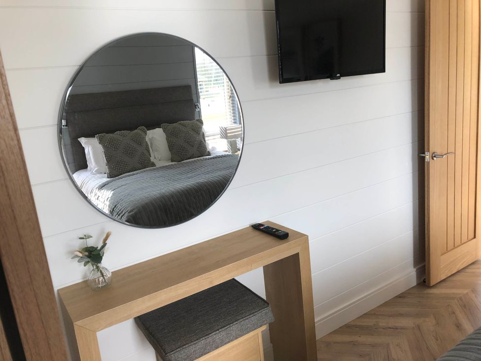 A bedroom with a mirror and television at Dream View in Waltham