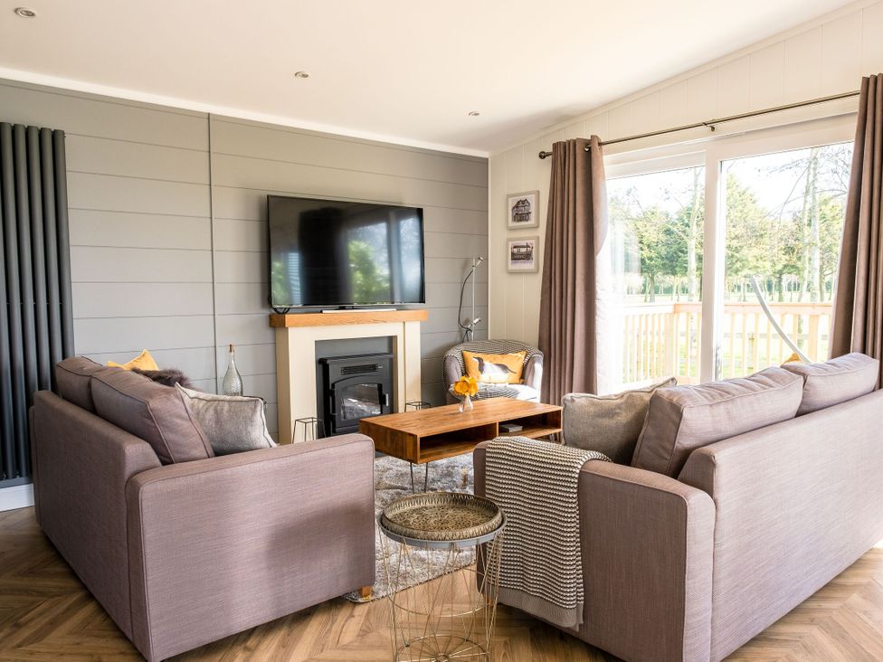 A living room with a television and sofa at Goldfinch in Waltham