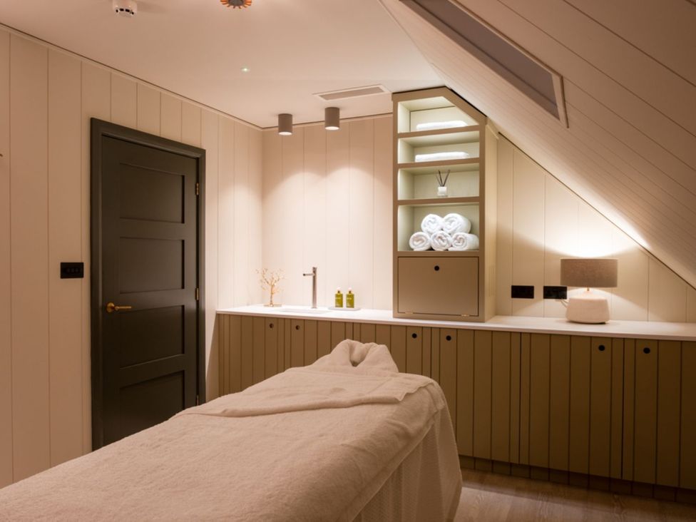 A spa room with a massage table and towels at Goldfinch in Waltham