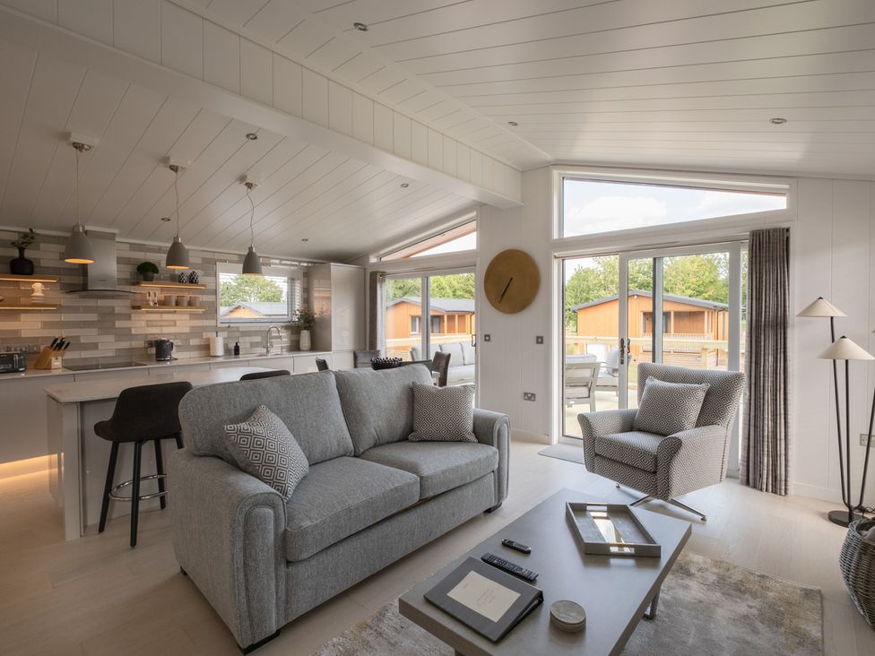 A living room with a sofa and kitchen area at The Luxury Hideaway in Waltham