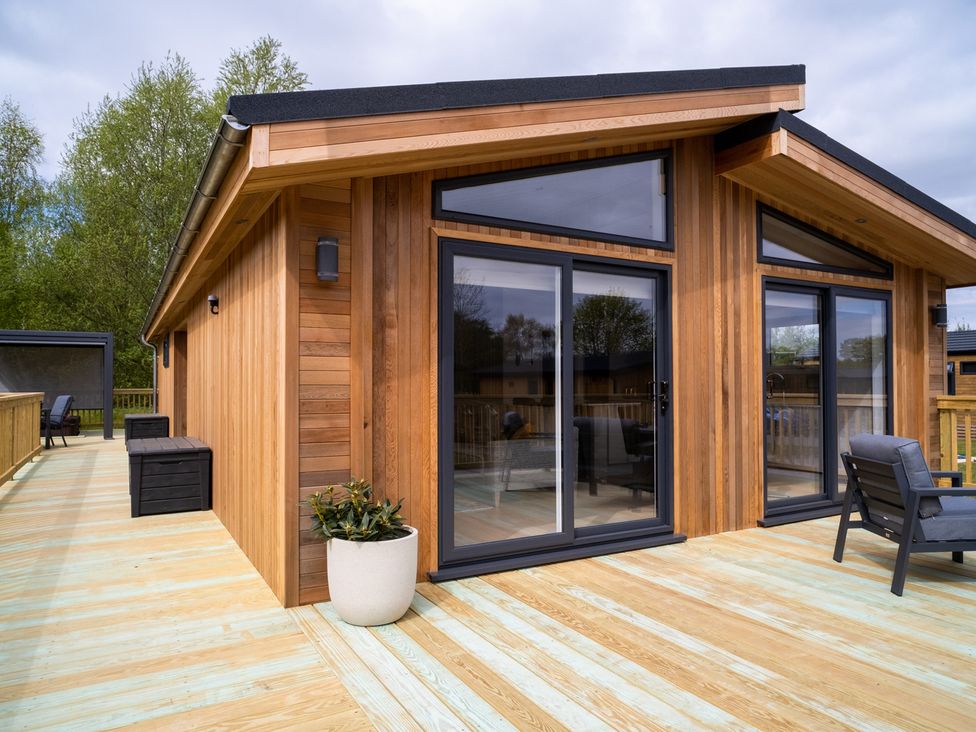 A wooden exterior with large windows and decking at The Luxury Hideaway in Waltham