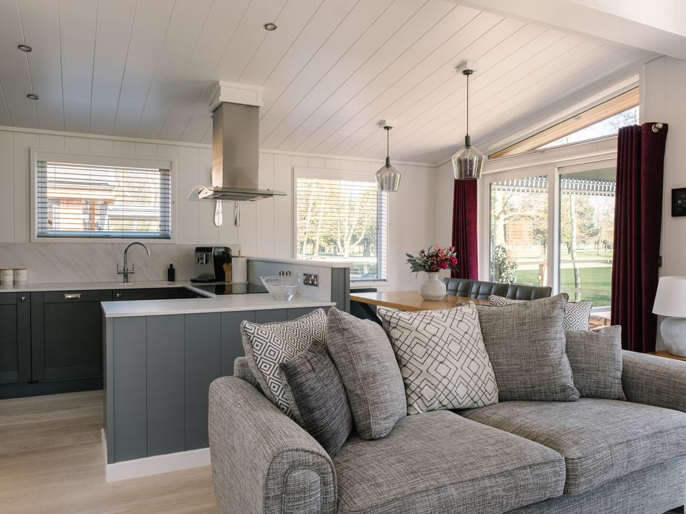 A living room with a sofa and kitchen counter at The Luxury Hideaway in Waltham