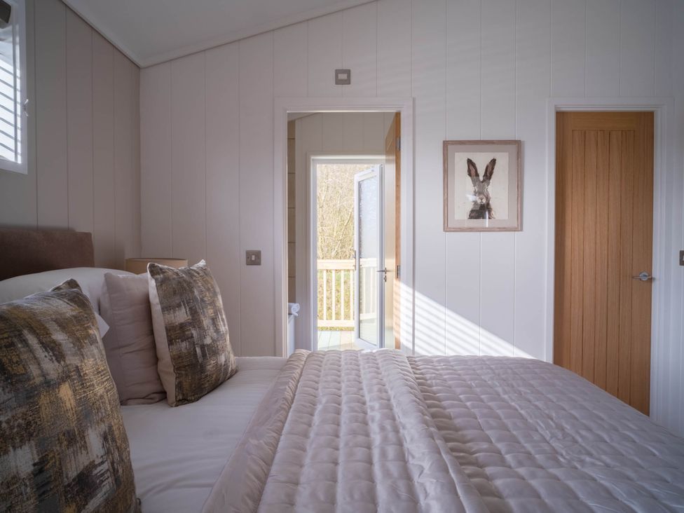 A bedroom with a bed and doors leading outside at Luxurious Serenity in Waltham