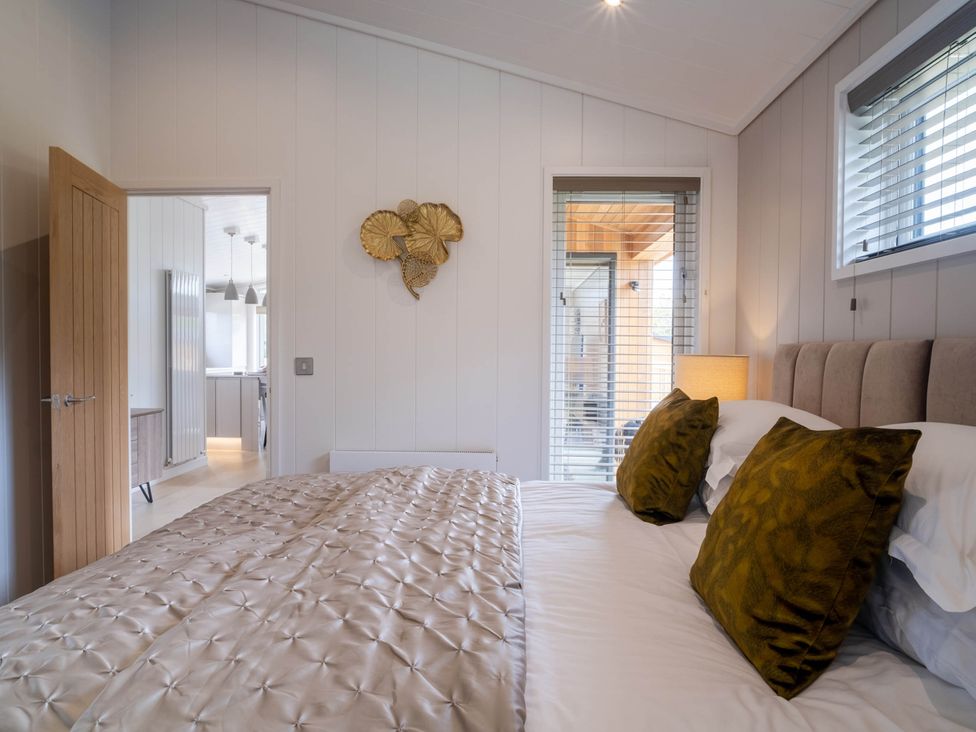 A bedroom with a bed and a bedside lamp at The Luxury Escape in Waltham