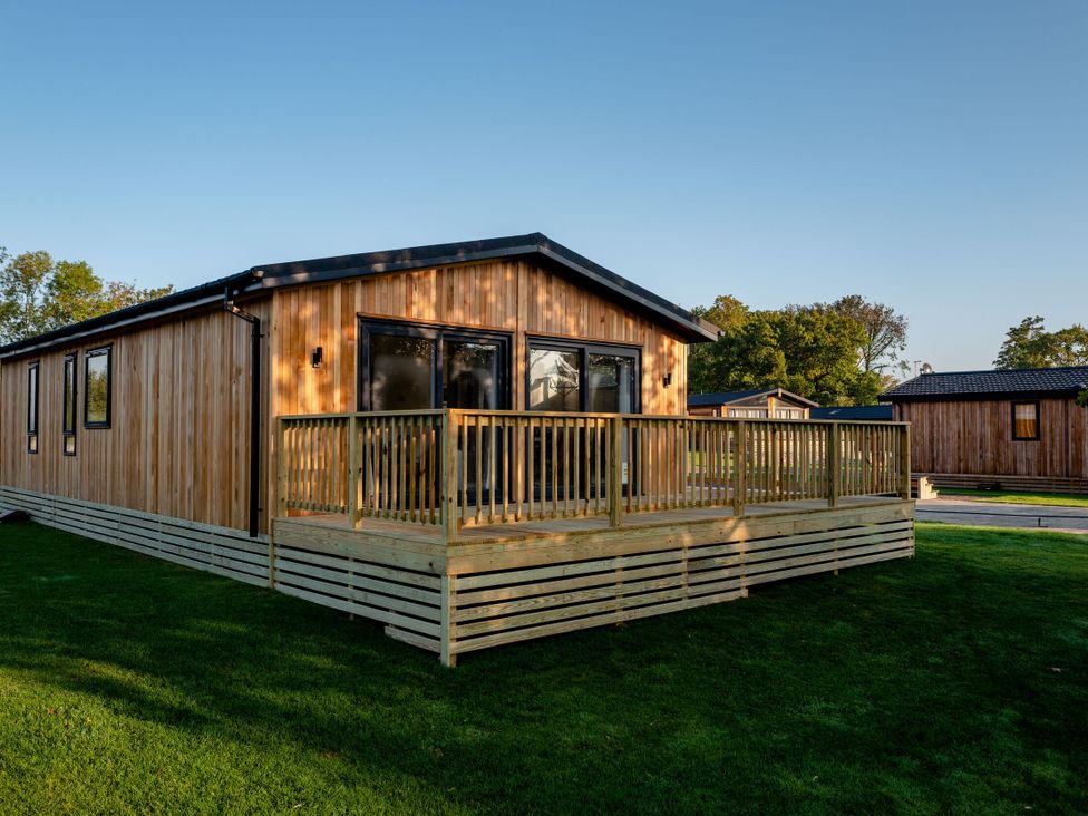 A wooden house with a decking area at Dovecote in Waltham