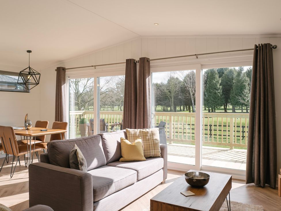 A living room with a sofa and dining area at Dovecote in Waltham