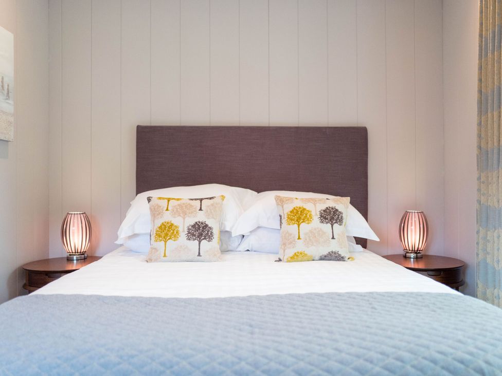 A bedroom with a bed and decorative pillows at The Henley in Waltham