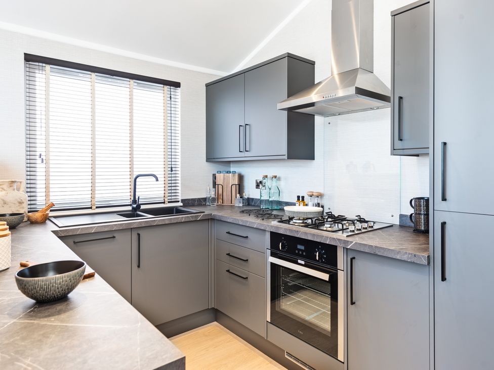A kitchen with grey cabinets and appliances at Shangri-La in Waltham