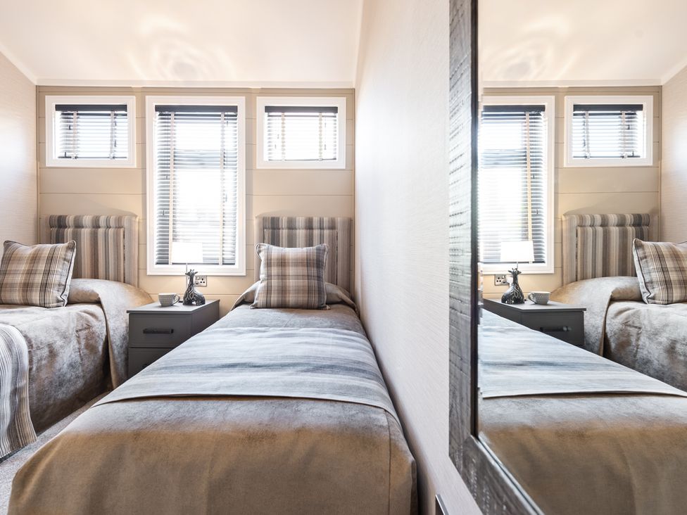 A bedroom with two single beds and a bedside table at Shangri-La in Waltham