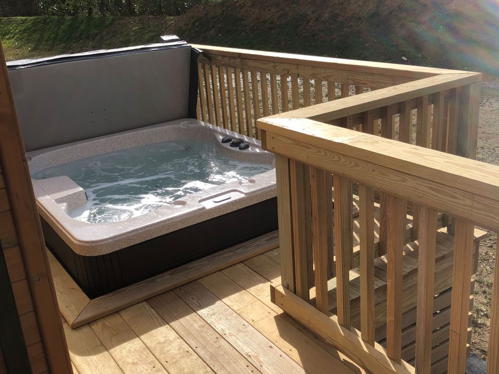 A hot tub on a wooden deck at Shangri-La in Waltham
