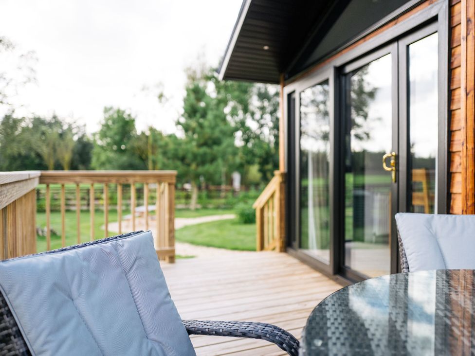 An outdoor space with a table and chairs on the decking at Macosi in Waltham
