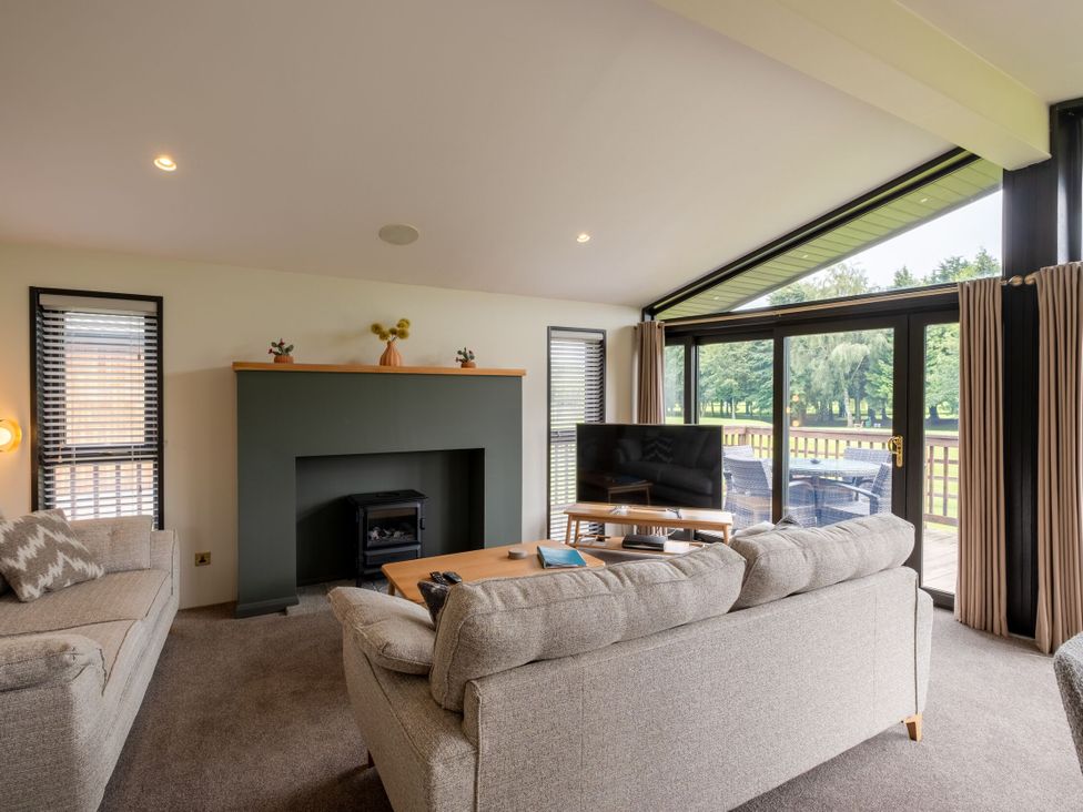 A living room with a fireplace and television at Macosi in Waltham
