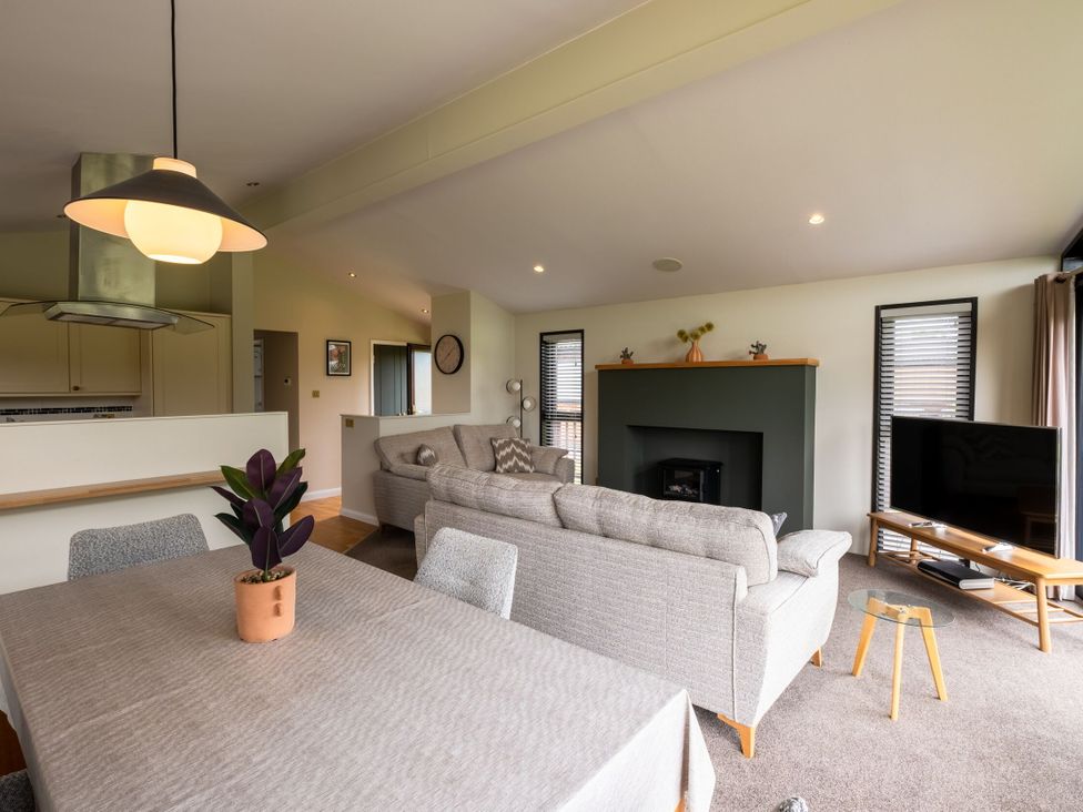 A living room with a fireplace and television at Macosi in Waltham