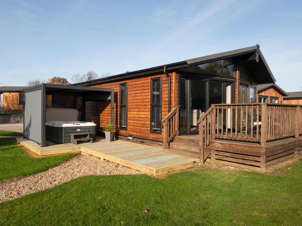 A wooden house with a hot tub on the patio at Macosi in Waltham