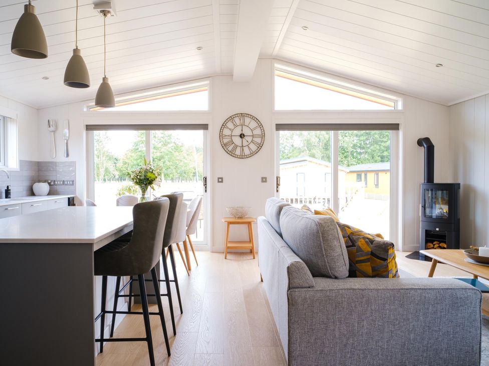 A living room with a fireplace and kitchen island at The Luxury Retreat in Waltham